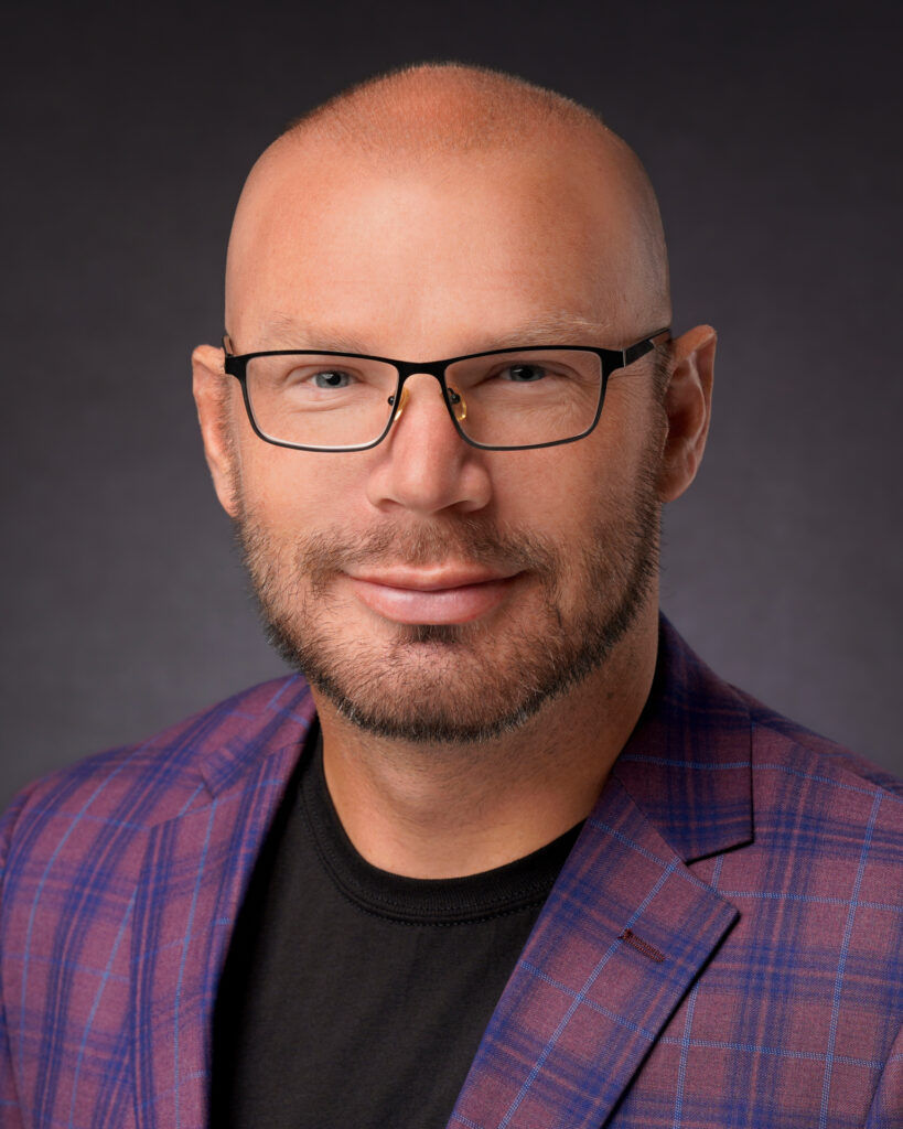 Professional headshot of a Marketing Director in business attire, smiling confidently against a neutral background.
