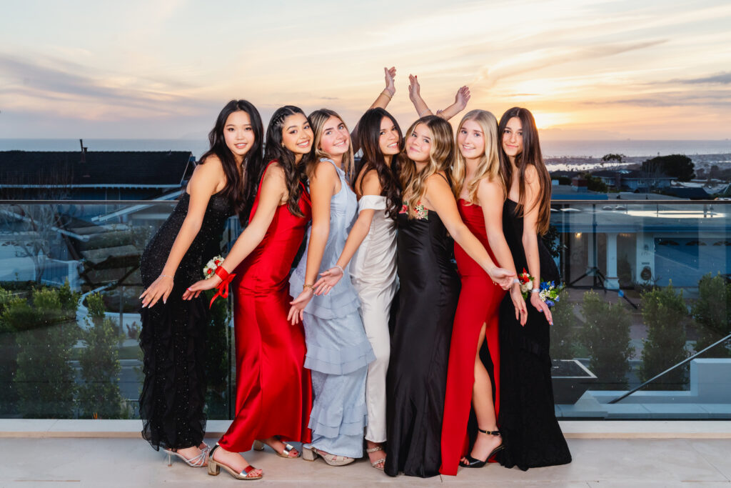 Teenage girls in formal dresses smiling and posing together at Pacific High School’s Winter Formal Dance.