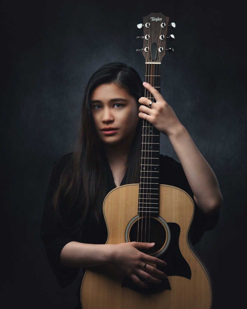 Portrait of a confident songwriter and singer during a branding photo shoot by Art of Portraits, highlighting artistic style and personal brand in a modern studio.