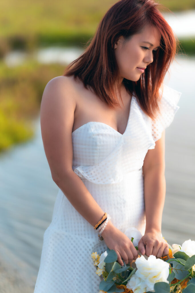 Lifestyle portrait of a woman outdoors in soft natural light, showcasing authentic emotion and relaxed elegance in a natural setting.