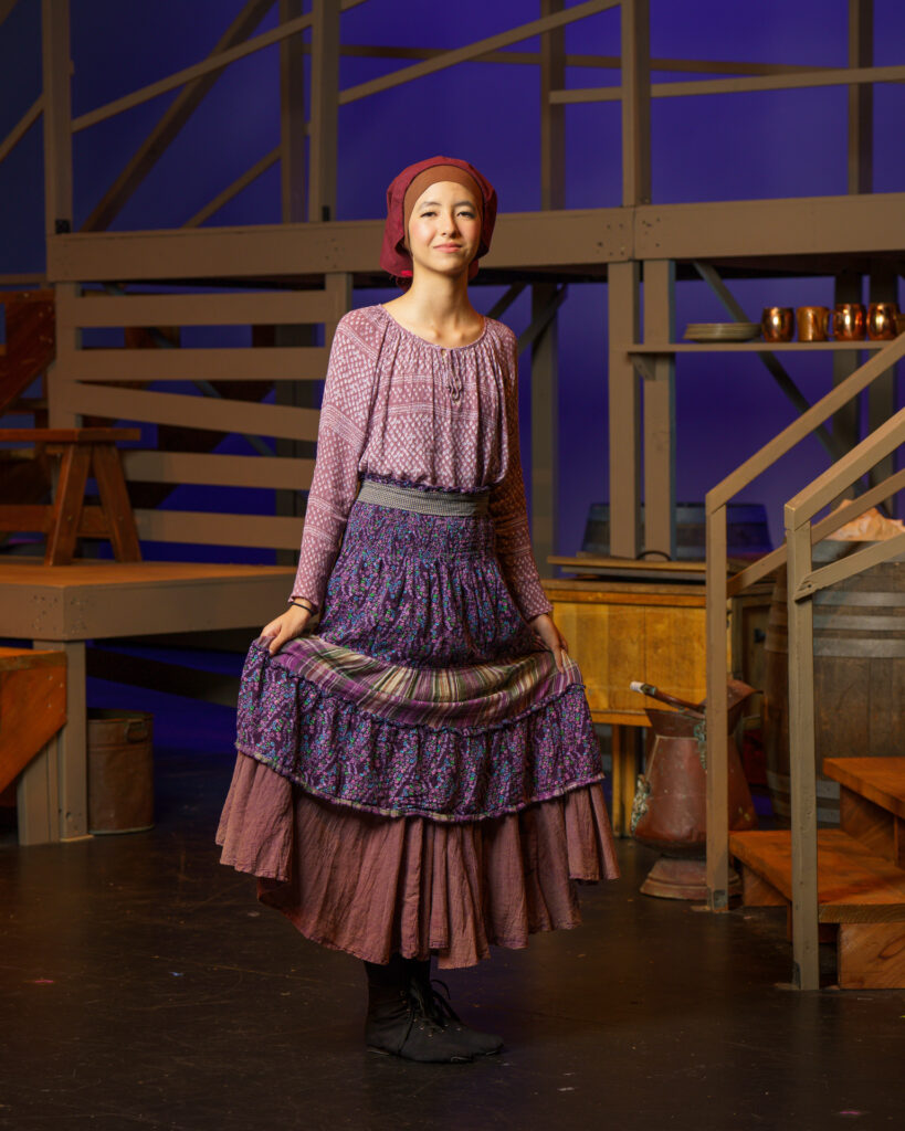 An actress in period costume on stage