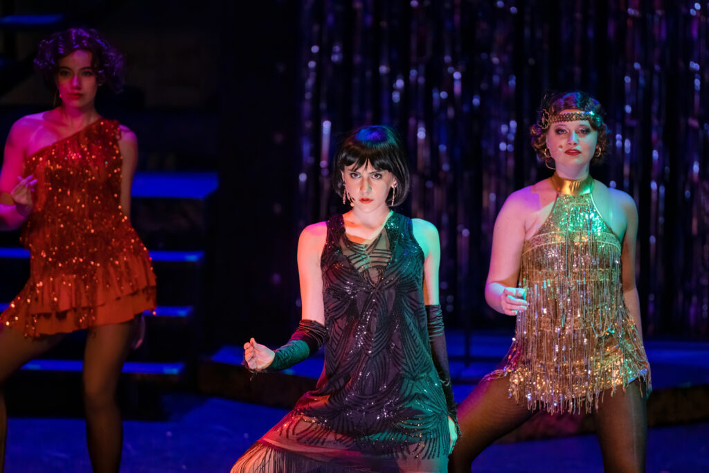 Dancers in sparkling costumes performing on stage.